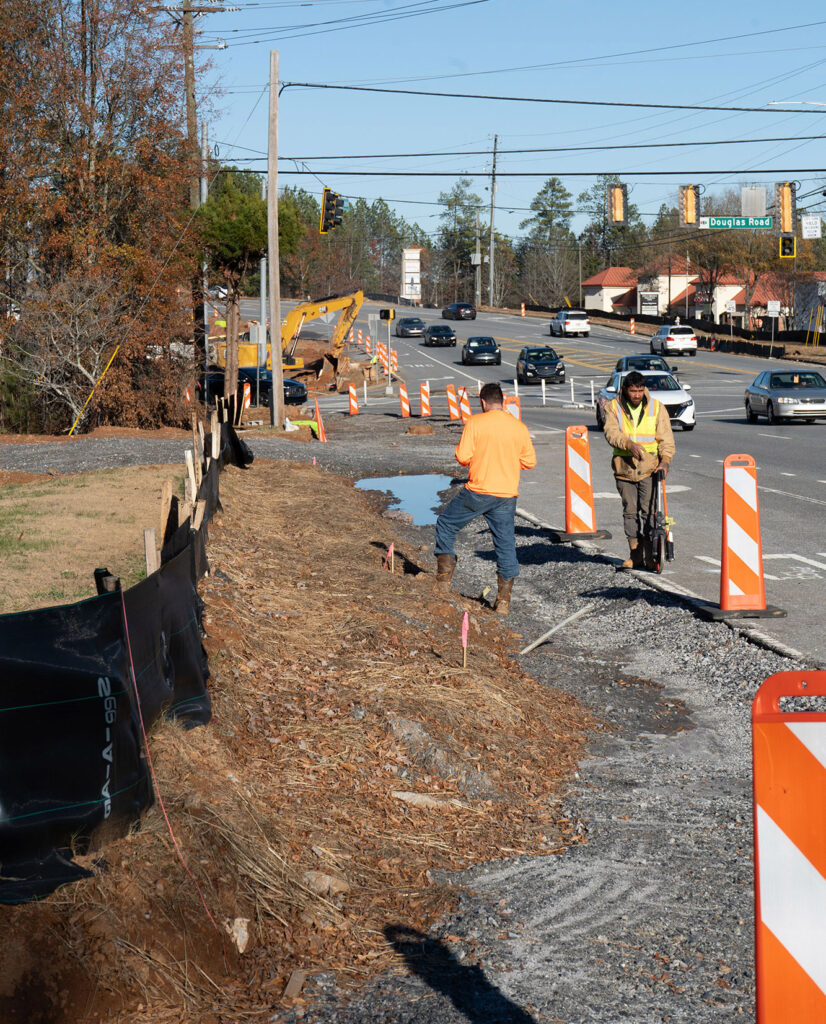 Workers installing sidewalk along Jones Bridge Road